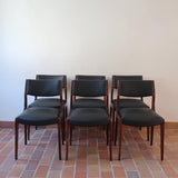 Lot de six chaises scandinaves vintage en teck massif avec assise et dossier en skaï noir, style Niels Otto Møller ou Erik Buch, présentées seules et en mise en situation dans différents espaces.