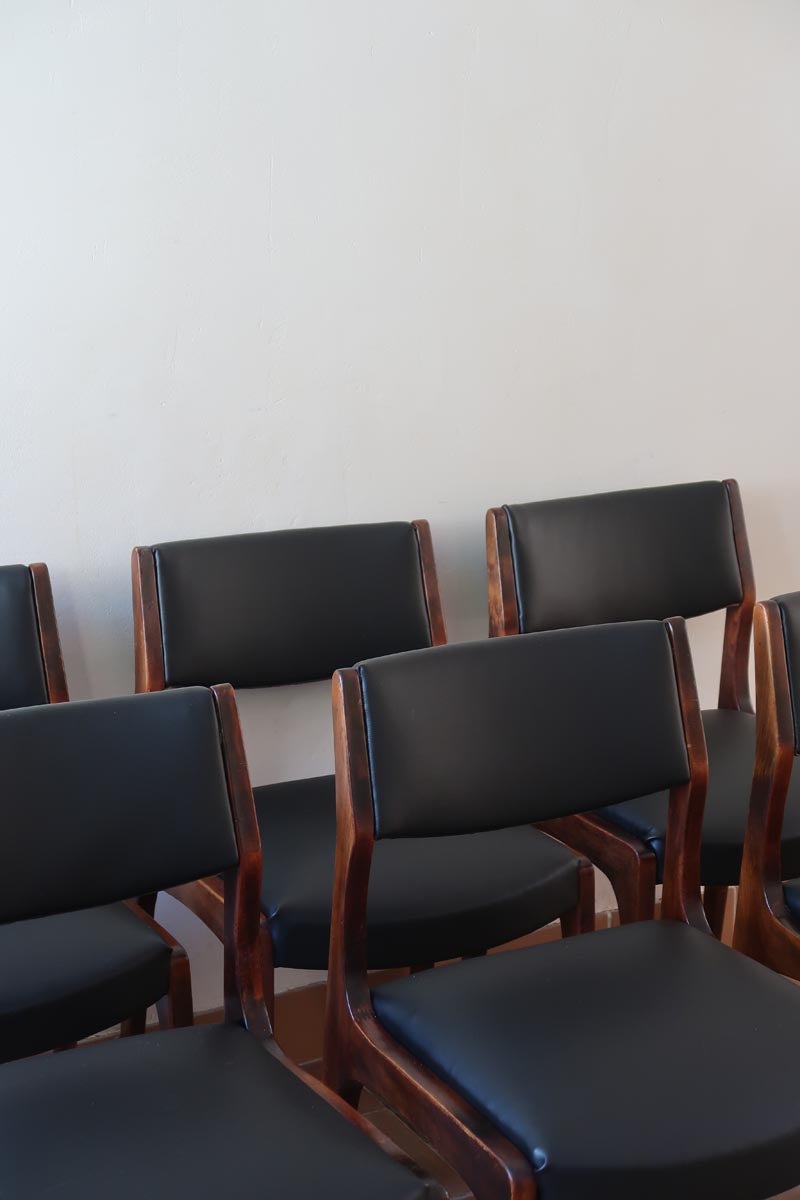 Lot de six chaises scandinaves vintage en teck massif avec assise et dossier en skaï noir, style Niels Otto Møller ou Erik Buch, présentées seules et en mise en situation dans différents espaces.