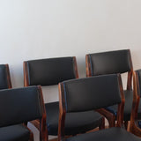 Lot de six chaises scandinaves vintage en teck massif avec assise et dossier en skaï noir, style Niels Otto Møller ou Erik Buch, présentées seules et en mise en situation dans différents espaces.