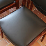 Lot de six chaises scandinaves vintage en teck massif avec assise et dossier en skaï noir, style Niels Otto Møller ou Erik Buch, présentées seules et en mise en situation dans différents espaces.