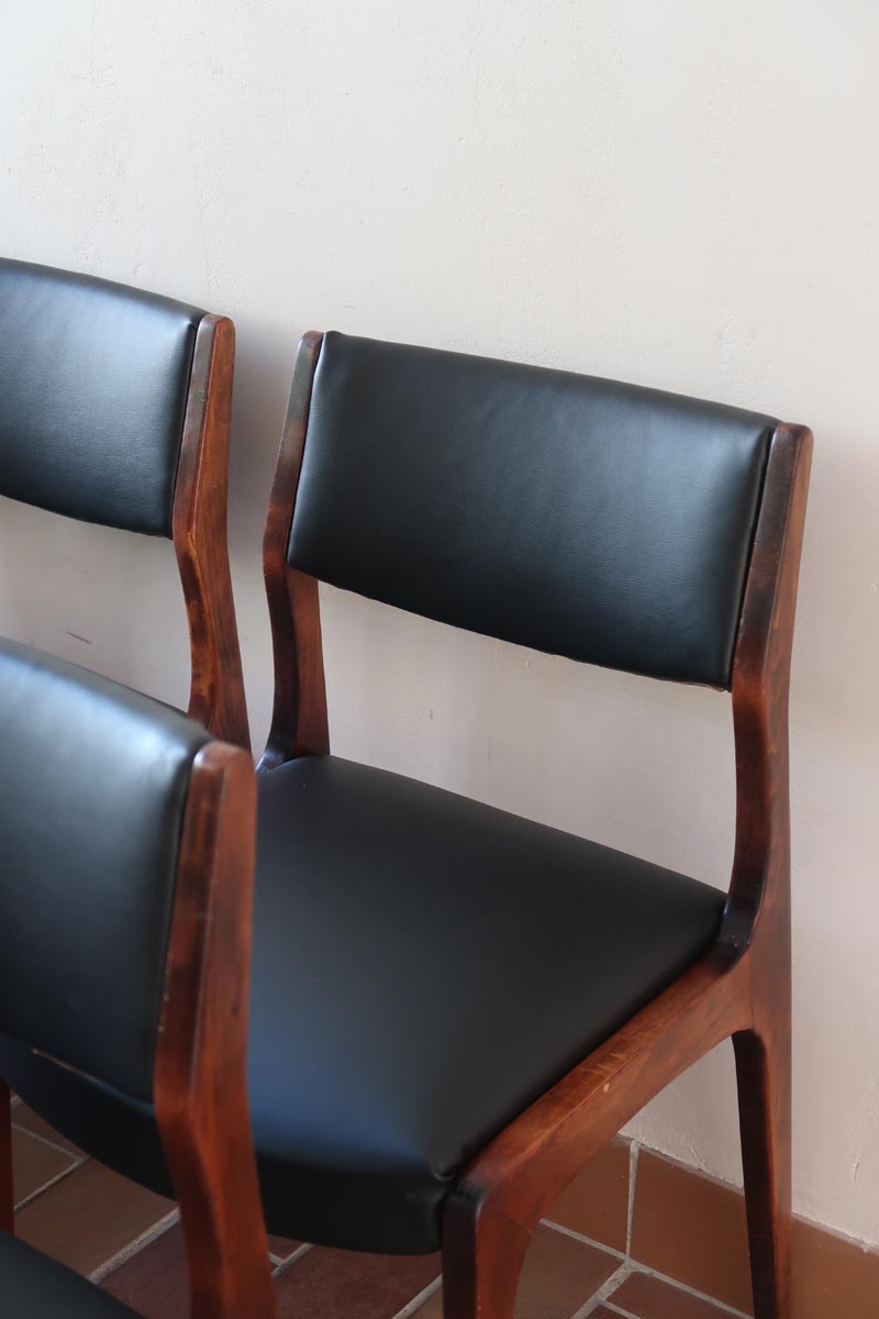 Lot de six chaises scandinaves vintage en teck massif avec assise et dossier en skaï noir, style Niels Otto Møller ou Erik Buch, présentées seules et en mise en situation dans différents espaces.