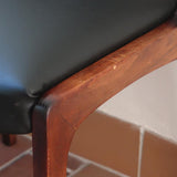 Lot de six chaises scandinaves vintage en teck massif avec assise et dossier en skaï noir, style Niels Otto Møller ou Erik Buch, présentées seules et en mise en situation dans différents espaces.