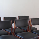 Lot de six chaises scandinaves vintage en teck massif avec assise et dossier en skaï noir, style Niels Otto Møller ou Erik Buch, présentées seules et en mise en situation dans différents espaces.