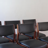 Lot de six chaises scandinaves vintage en teck massif avec assise et dossier en skaï noir, style Niels Otto Møller ou Erik Buch, présentées seules et en mise en situation dans différents espaces.