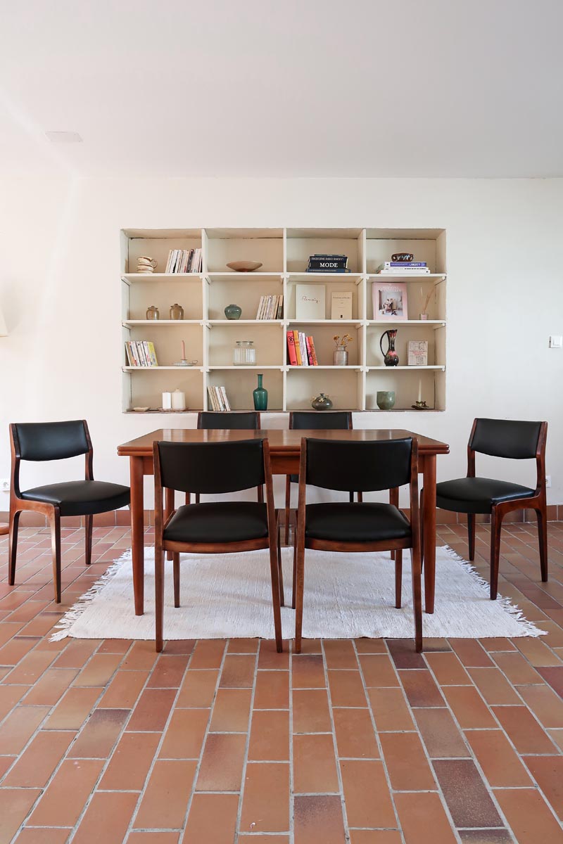 Lot de six chaises scandinaves vintage en teck massif avec assise et dossier en skaï noir, style Niels Otto Møller ou Erik Buch, présentées seules et en mise en situation dans différents espaces.