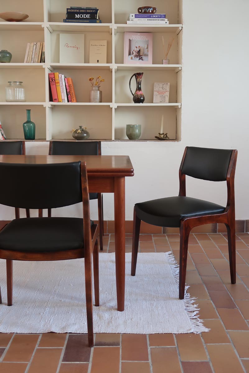 Lot de six chaises scandinaves vintage en teck massif avec assise et dossier en skaï noir, style Niels Otto Møller ou Erik Buch, présentées seules et en mise en situation dans différents espaces.