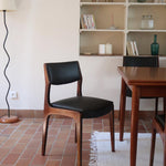 Lot de six chaises scandinaves vintage en teck massif avec assise et dossier en skaï noir, style Niels Otto Møller ou Erik Buch, présentées seules et en mise en situation dans différents espaces.