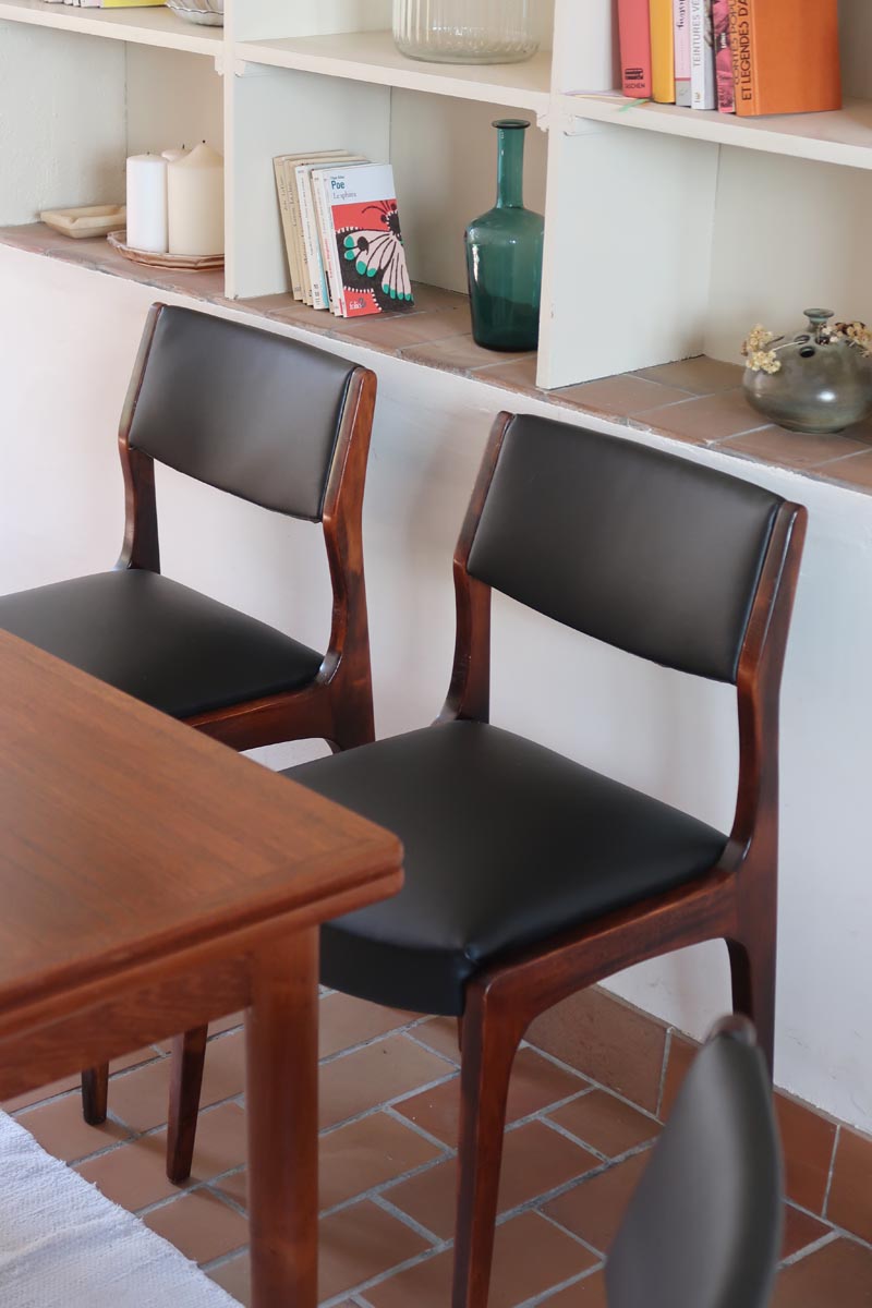 Lot de six chaises scandinaves vintage en teck massif avec assise et dossier en skaï noir, style Niels Otto Møller ou Erik Buch, présentées seules et en mise en situation dans différents espaces.