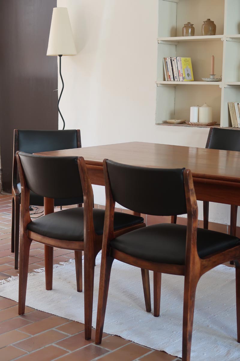 Lot de six chaises scandinaves vintage en teck massif avec assise et dossier en skaï noir, style Niels Otto Møller ou Erik Buch, présentées seules et en mise en situation dans différents espaces.