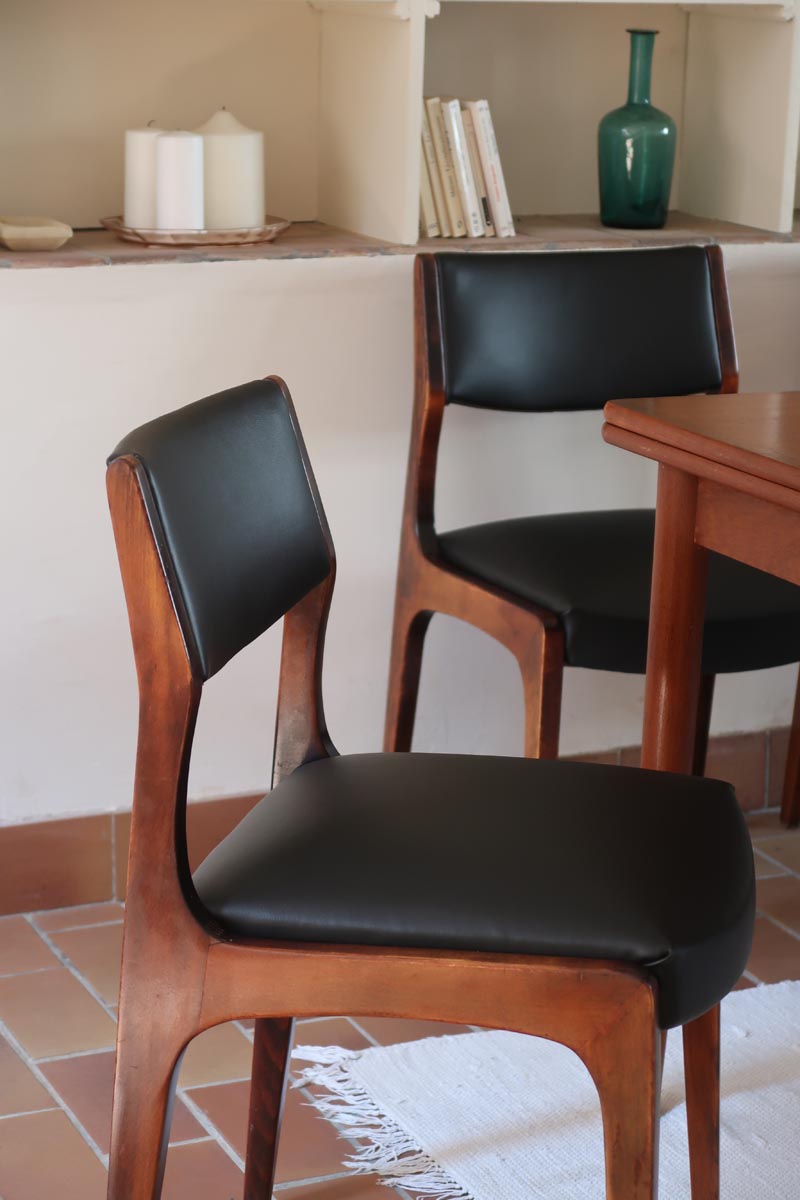 Lot de six chaises scandinaves vintage en teck massif avec assise et dossier en skaï noir, style Niels Otto Møller ou Erik Buch, présentées seules et en mise en situation dans différents espaces.