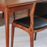 Lot de six chaises scandinaves vintage en teck massif avec assise et dossier en skaï noir, style Niels Otto Møller ou Erik Buch, présentées seules et en mise en situation dans différents espaces.