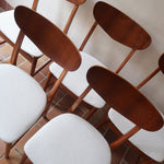Lot de 5 chaises scandinaves en teck années 60 avec dossier galbé et assises retapissées en bouclette écru.