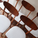 Lot de 5 chaises scandinaves en teck années 60 avec dossier galbé et assises retapissées en bouclette écru.