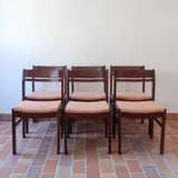 Lot de six chaises vintage en bois massif avec assise en velours couleur pêche, style Baumann ou Dyrlund, présentées seules et en mise en situation.