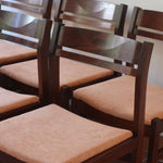 Lot de six chaises vintage en bois massif avec assise en velours couleur pêche, style Baumann ou Dyrlund, présentées seules et en mise en situation.