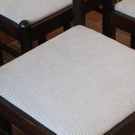 Lot de six chaises vintage en chêne massif teinté foncé avec assise en tissu clair à fines rayures, au design épuré et intemporel, présentées seules et en mise en situation.