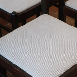 Lot de six chaises vintage en chêne massif teinté foncé avec assise en tissu clair à fines rayures, au design épuré et intemporel, présentées seules et en mise en situation.
