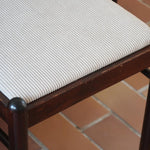 Lot de six chaises vintage en chêne massif teinté foncé avec assise en tissu clair à fines rayures, au design épuré et intemporel, présentées seules et en mise en situation.