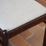 Lot de six chaises vintage en chêne massif teinté foncé avec assise en tissu clair à fines rayures, au design épuré et intemporel, présentées seules et en mise en situation.