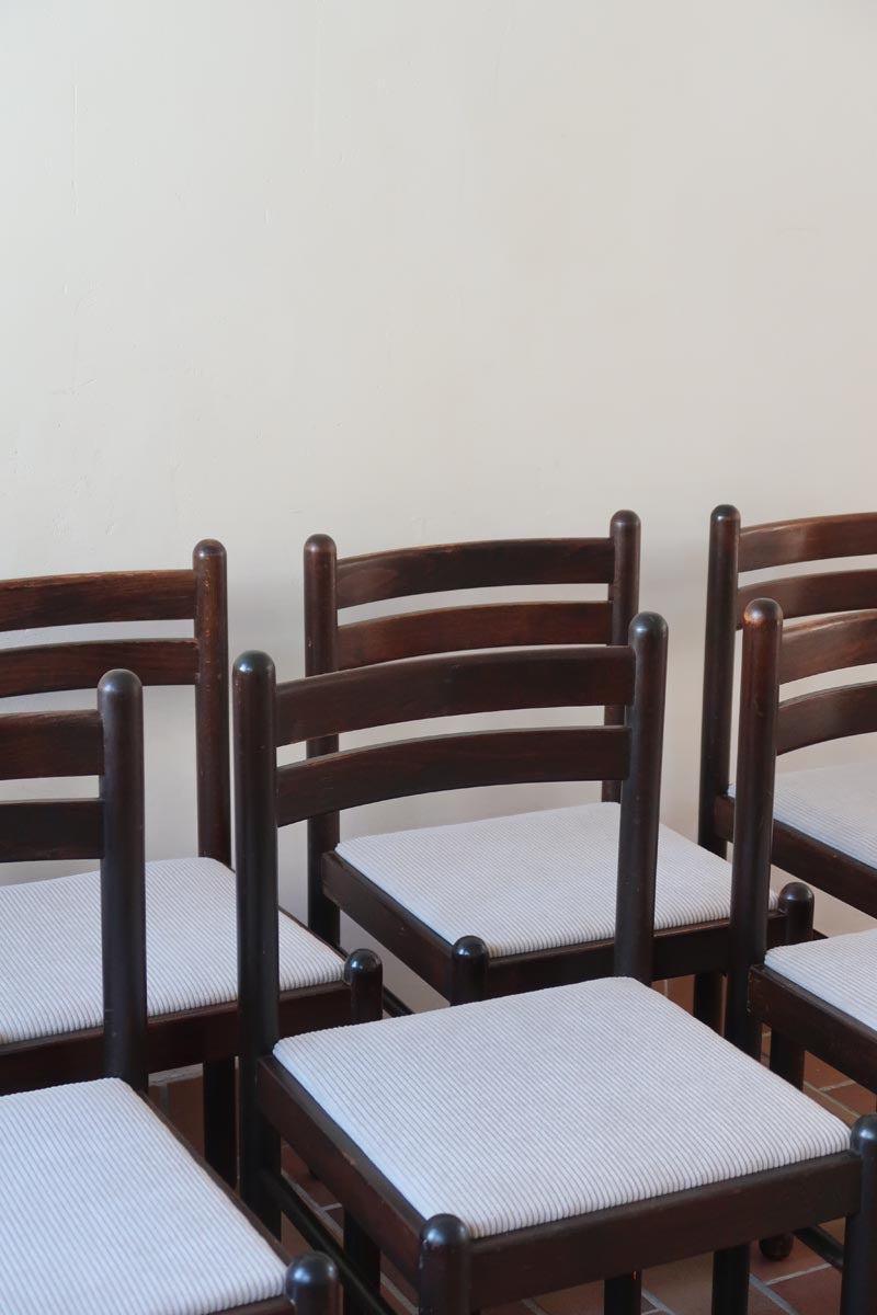 Lot de six chaises vintage en chêne massif teinté foncé avec assise en tissu clair à fines rayures, au design épuré et intemporel, présentées seules et en mise en situation.