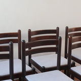 Lot de six chaises vintage en chêne massif teinté foncé avec assise en tissu clair à fines rayures, au design épuré et intemporel, présentées seules et en mise en situation.