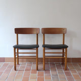 Paire de chaises scandinaves en bois et skaï noir — années 60