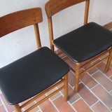 Paire de chaises scandinaves en bois et skaï noir — années 60