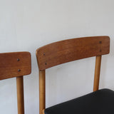 Paire de chaises scandinaves en bois et skaï noir — années 60