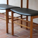 Paire de chaises scandinaves en bois et skaï noir — années 60