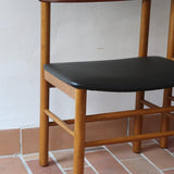 Paire de chaises scandinaves en bois et skaï noir — années 60