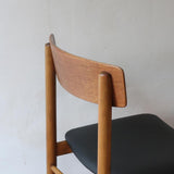 Paire de chaises scandinaves en bois et skaï noir — années 60