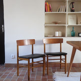 Paire de chaises scandinaves en bois et skaï noir — années 60