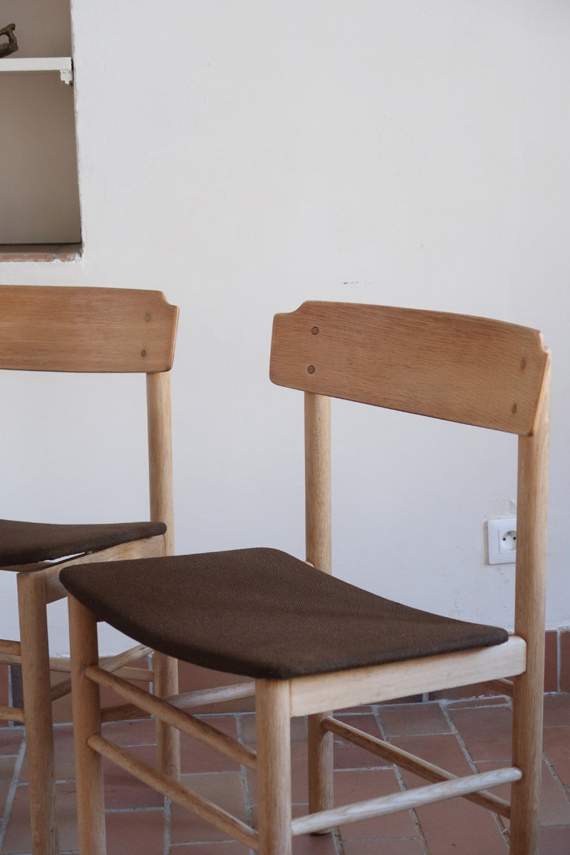 Paire de chaises scandinaves en bois clair avec assises en cuir brun, design des années 1960.