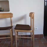 Paire de chaises scandinaves en bois clair avec assises en cuir brun, design des années 1960.