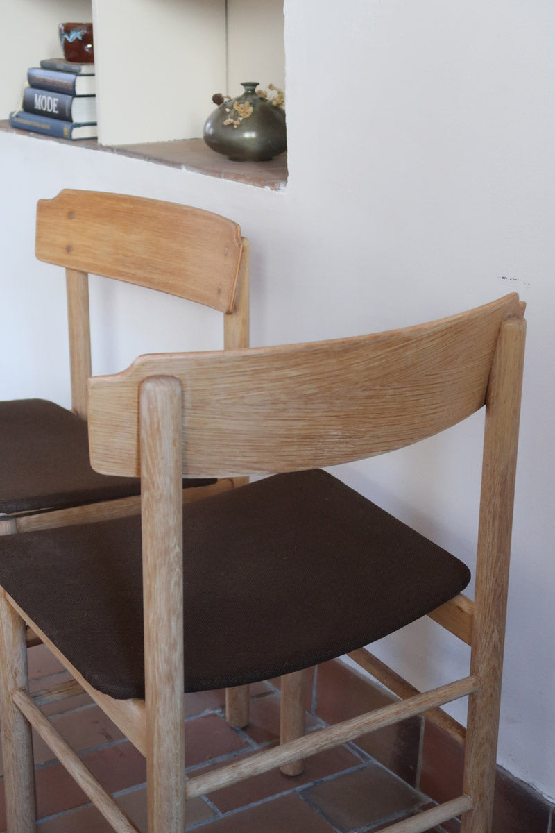 Paire de chaises scandinaves en bois clair avec assises en cuir brun, design des années 1960.
