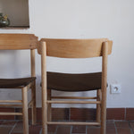 Paire de chaises scandinaves en bois clair avec assises en cuir brun, design des années 1960.