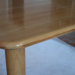 Table italienne en bois clair avec piétement cylindrique massif, design des années 1990.