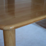 Table italienne en bois clair avec piétement cylindrique massif, design des années 1990.