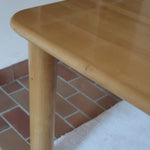 Table italienne en bois clair avec piétement cylindrique massif, design des années 1990.