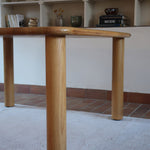 Table italienne en bois clair avec piétement cylindrique massif, design des années 1990.