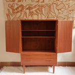 Armoire vintage en bois des années 60 avec deux portes, deux tiroirs, poignées sculptées et pieds compas.