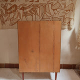 Armoire vintage en bois des années 60 avec deux portes, deux tiroirs, poignées sculptées et pieds compas.