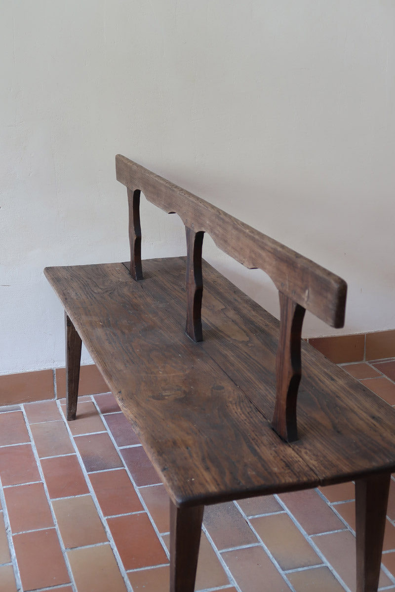 Banc rustique ancien bois massif chantourné, dossier ajouré montants festonnés, assise planche pleine patinée, mobilier vernaculaire français campagne