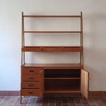 Bibliothèque secrétaire scandinave vintage des années 60 en teck et hêtre, avec étagères, tiroirs et placard, présentée seule et en mise en situation.