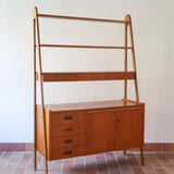 Bibliothèque secrétaire scandinave vintage des années 60 en teck et hêtre, avec étagères, tiroirs et placard, présentée seule et en mise en situation.
