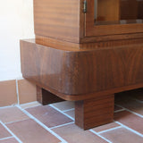 Bibliothèque vitrée vintage en bois de noyer, années 60, esprit Art déco, deux portes vitrées à encadrement de bois fermant à clé, quatre tablettes réglables, socle débordant à gradins sur deux patins pleins