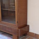 Bibliothèque vitrée vintage en bois de noyer, années 60, esprit Art déco, deux portes vitrées à encadrement de bois fermant à clé, quatre tablettes réglables, socle débordant à gradins sur deux patins pleins