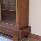 Bibliothèque vitrée vintage en bois de noyer, années 60, esprit Art déco, deux portes vitrées à encadrement de bois fermant à clé, quatre tablettes réglables, socle débordant à gradins sur deux patins pleins
