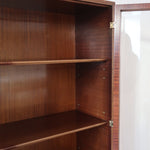 Bibliothèque vitrée vintage en bois de noyer, années 60, esprit Art déco, deux portes vitrées à encadrement de bois fermant à clé, quatre tablettes réglables, socle débordant à gradins sur deux patins pleins