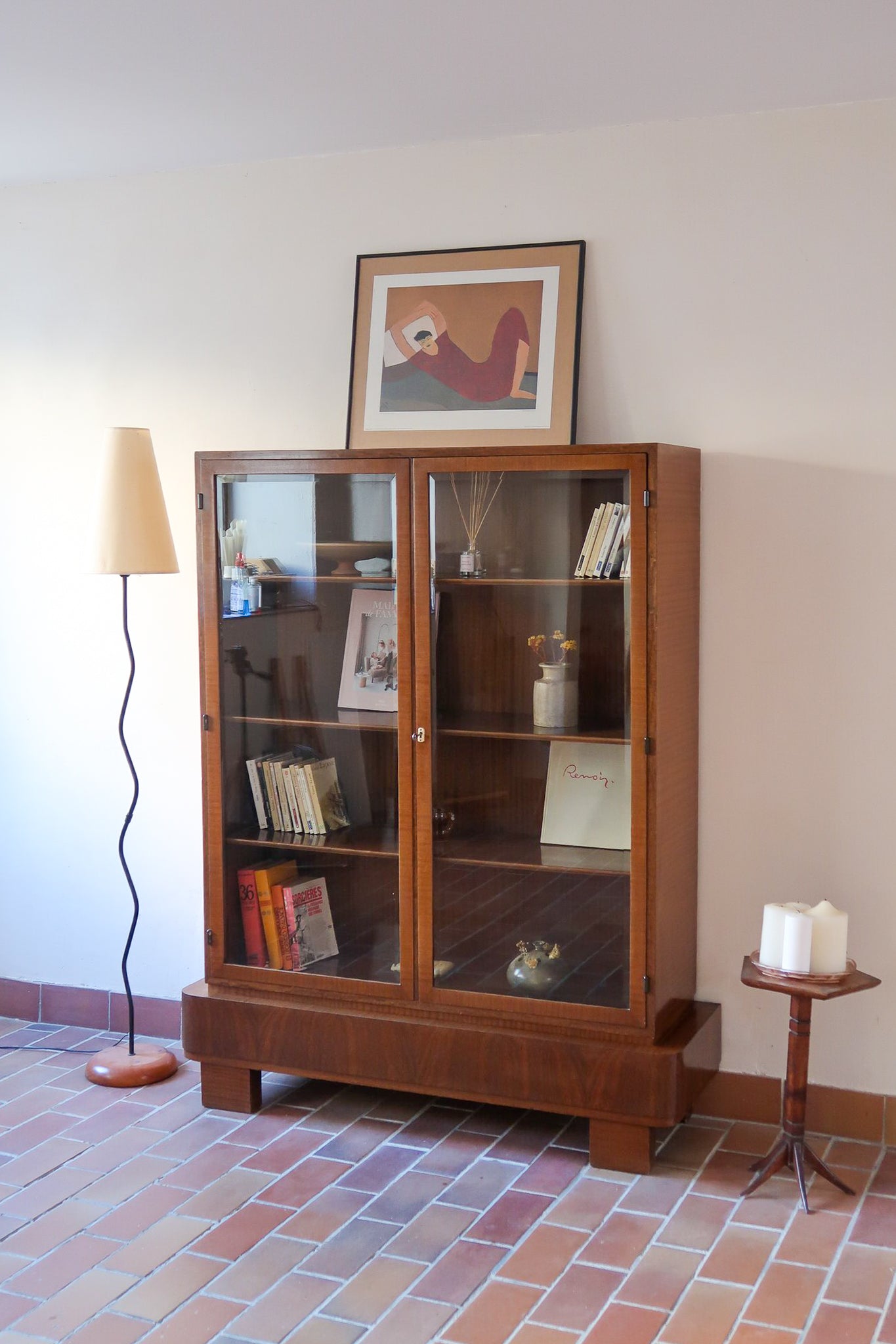 Bibliothèque vitrée vintage en bois de noyer, années 60, esprit Art déco, deux portes vitrées à encadrement de bois fermant à clé, quatre tablettes réglables, socle débordant à gradins sur deux patins pleins